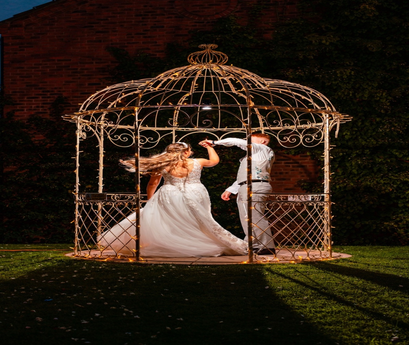 Wedding couple dancing under the illuminated gazebo at Oak Farm Hotel