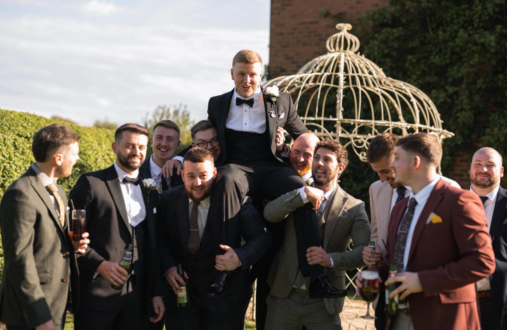 Groom celebrating with friends beside the gazebo at Oak Farm Hotel